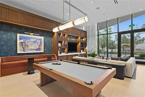a room with furniture pool table and flat screen tv