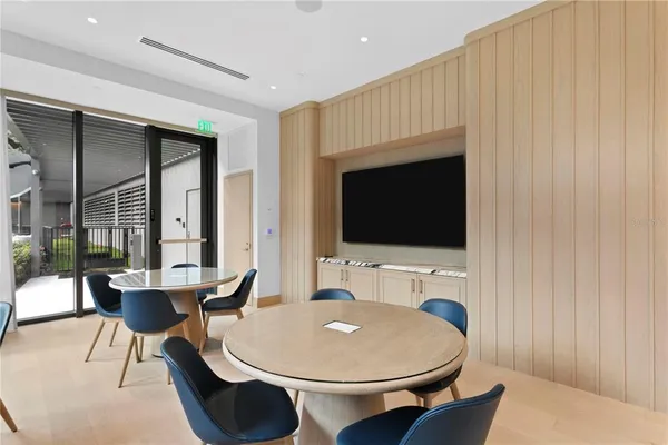 a living room with dining table and a flat screen tv