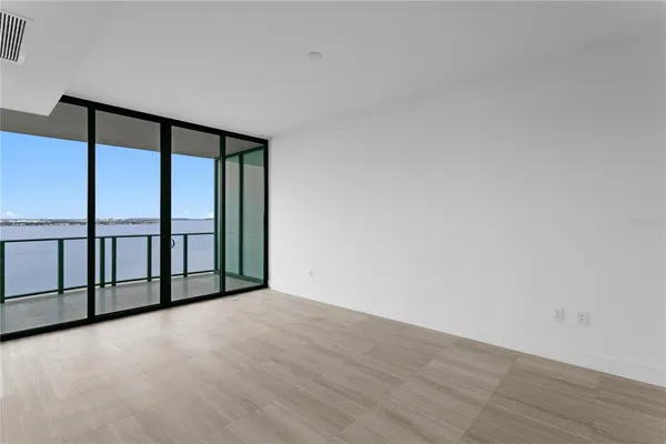 a view of a big room with wooden floor and windows