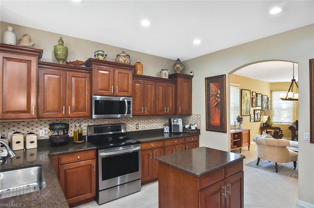 12421 Rock Ridge Lane Fort Myers, FL 33913 - Photo 11 of 50 a kitchen with granite countertop a stove top oven a sink dishwasher and cabinets with wooden floor