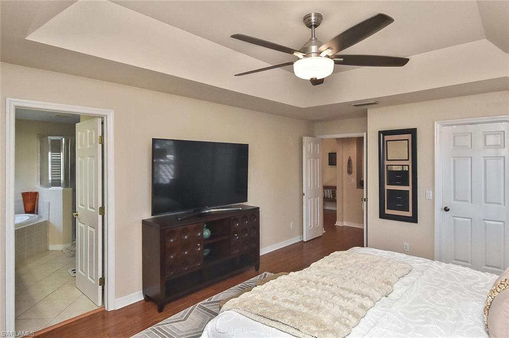 12421 Rock Ridge Lane Fort Myers, FL 33913 - Photo 25 of 50 a bedroom with a bed and a flat screen tv