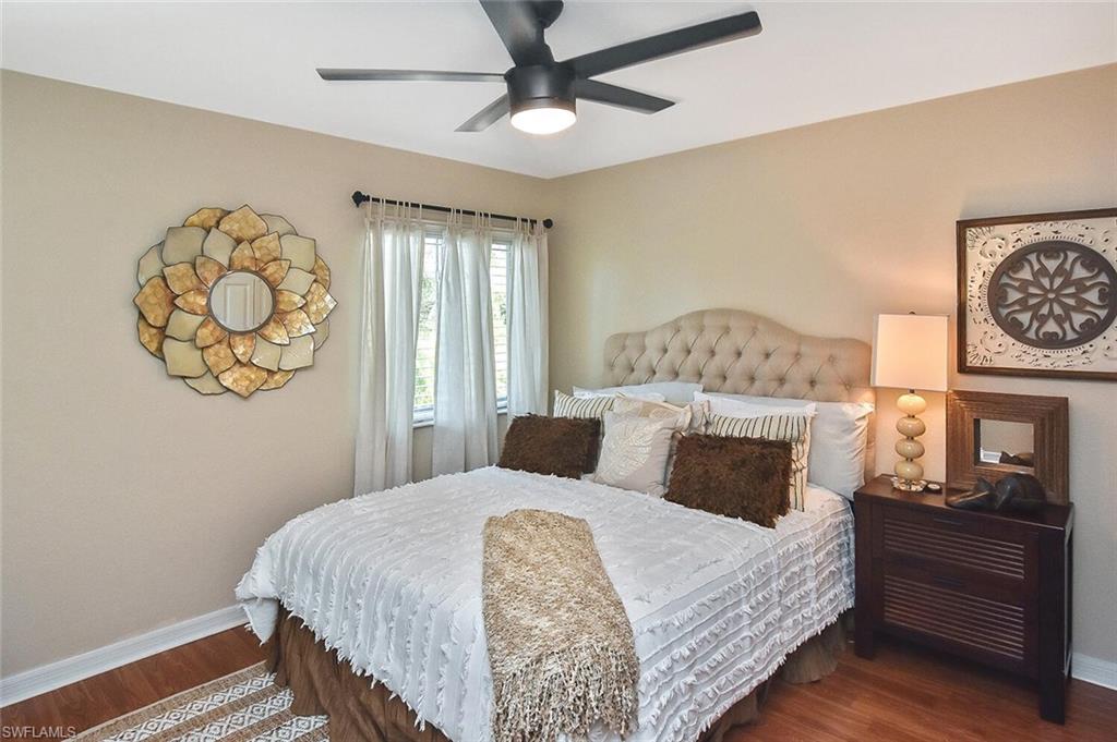 12421 Rock Ridge Lane Fort Myers, FL 33913 - Photo 29 of 50 a bedroom with a bed and a chandelier