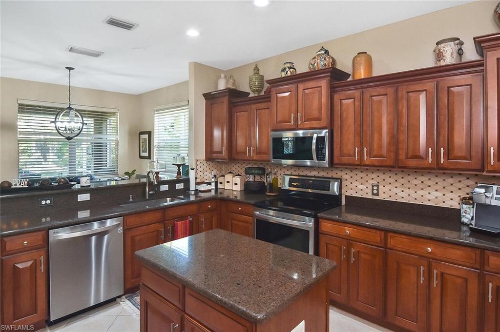 12421 Rock Ridge Lane Fort Myers, FL 33913 - Photo 3 of 50 a kitchen with stainless steel appliances granite countertop a sink stove microwave and refrigerator