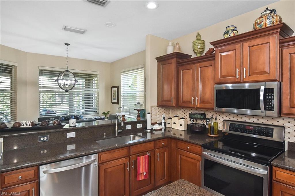 12421 Rock Ridge Lane Fort Myers, FL 33913 - Photo 9 of 50 a kitchen with stainless steel appliances a stove sink microwave and cabinets