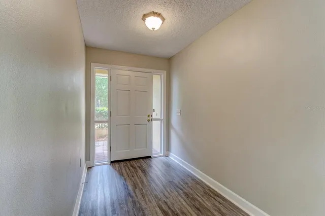 a kitchen with stainless steel appliances granite countertop a sink a stove a refrigerator a microwave oven with white cabinets