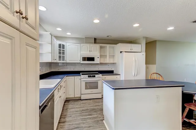 a kitchen with stainless steel appliances granite countertop a stove a sink a dining table and chairs