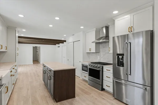 a kitchen with stainless steel appliances granite countertop a refrigerator a sink and a stove