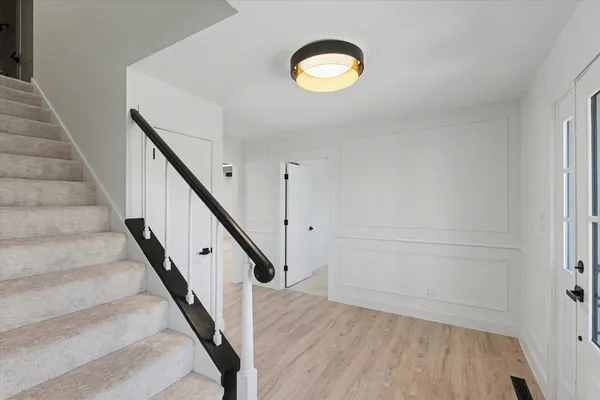 a view of staircase with railing and white walls
