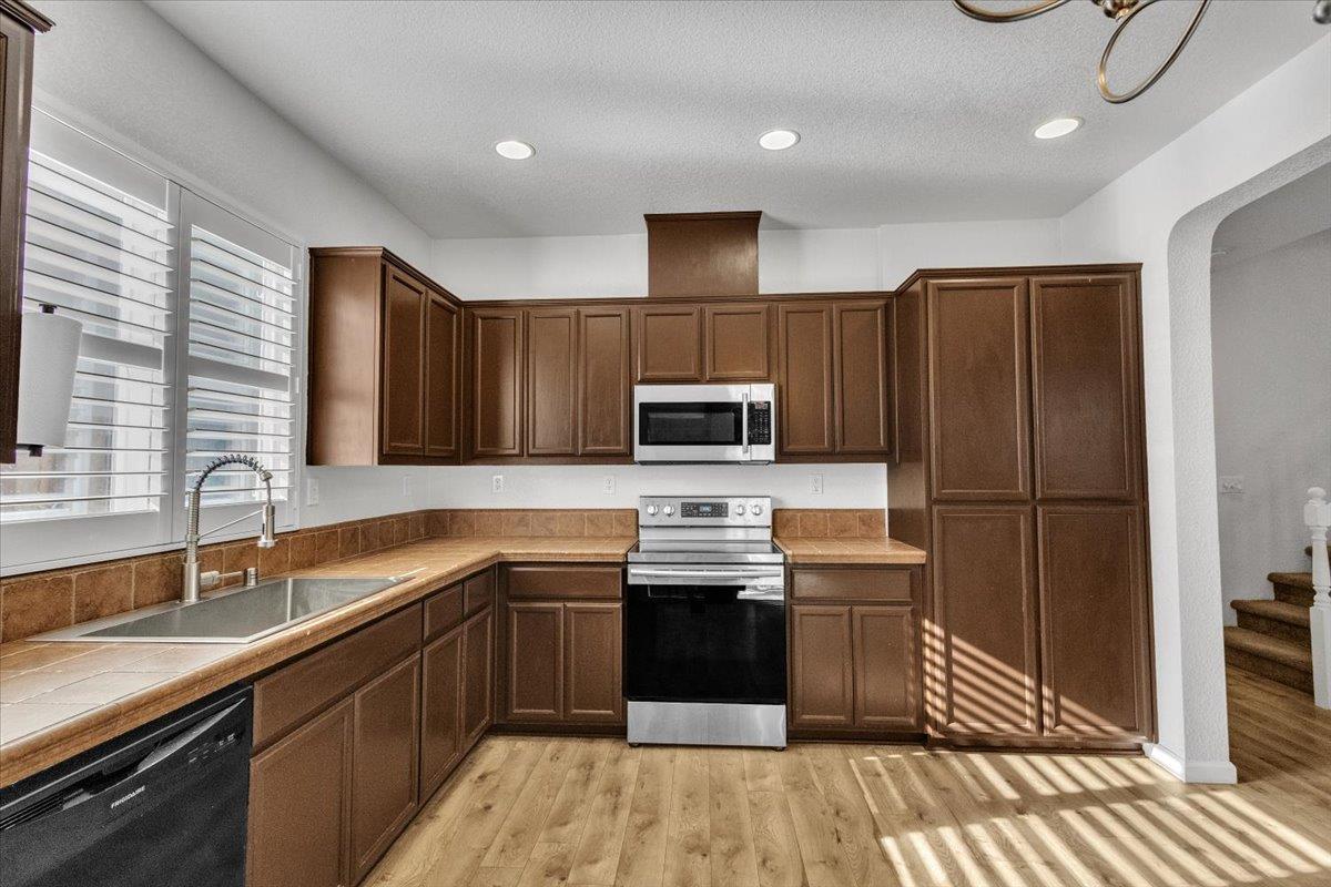 2608 Greenleaf Street Manteca, CA 95337 - Photo 11 of 65 a kitchen with stainless steel appliances granite countertop a sink stove and refrigerator