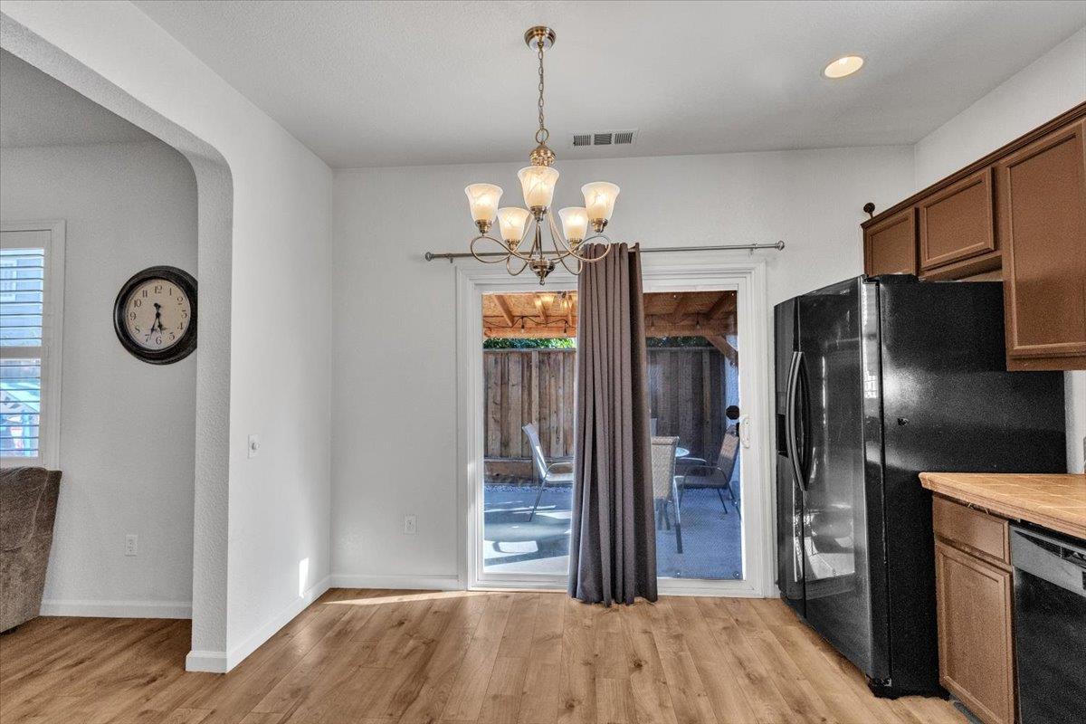 2608 Greenleaf Street Manteca, CA 95337 - Photo 15 of 65 a view of a hallway with wooden floor and a chandelier