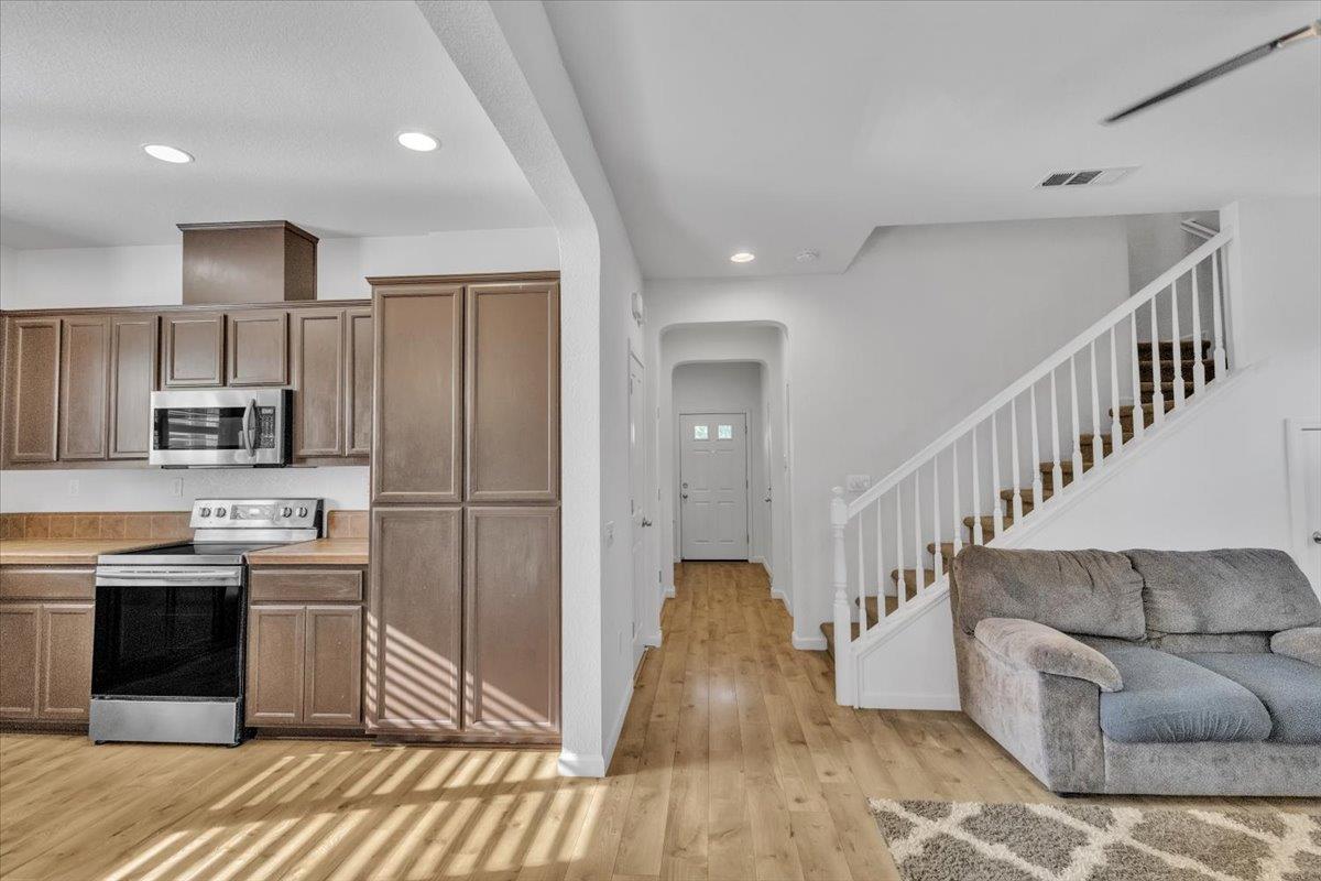 2608 Greenleaf Street Manteca, CA 95337 - Photo 18 of 65 a kitchen with stainless steel appliances kitchen island granite countertop a refrigerator a stove and a sink with wooden floor