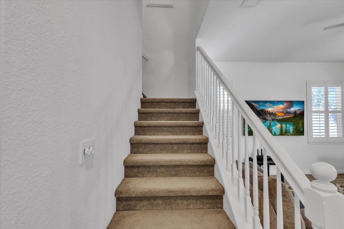 2608 Greenleaf Street Manteca, CA 95337 - Photo 23 of 65 a view of staircase with lots of frames on wall and a window