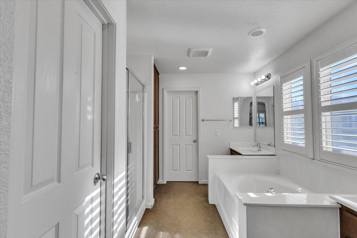 2608 Greenleaf Street Manteca, CA 95337 - Photo 29 of 65 a bathroom with a tub a sink and a large mirror