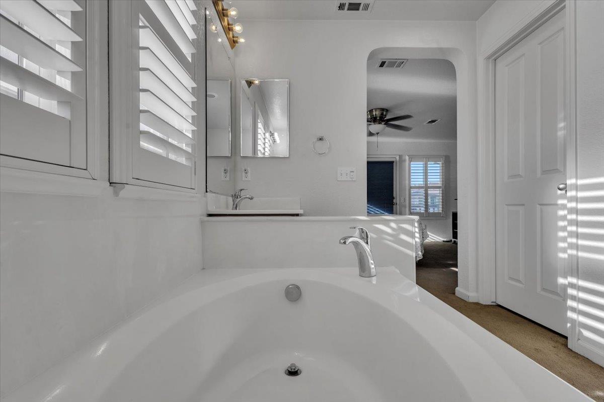 2608 Greenleaf Street Manteca, CA 95337 - Photo 37 of 65 a bathroom with a tub a mirror and a shower