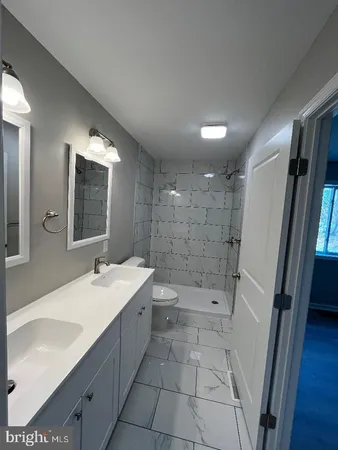 a bathroom with a bathtub shower sink and mirror