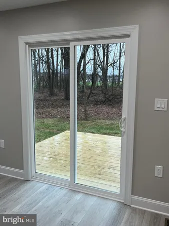 an empty room with wooden floor and a window