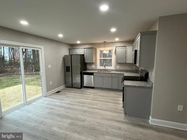 a view of kitchen with refrigerator sink and large window