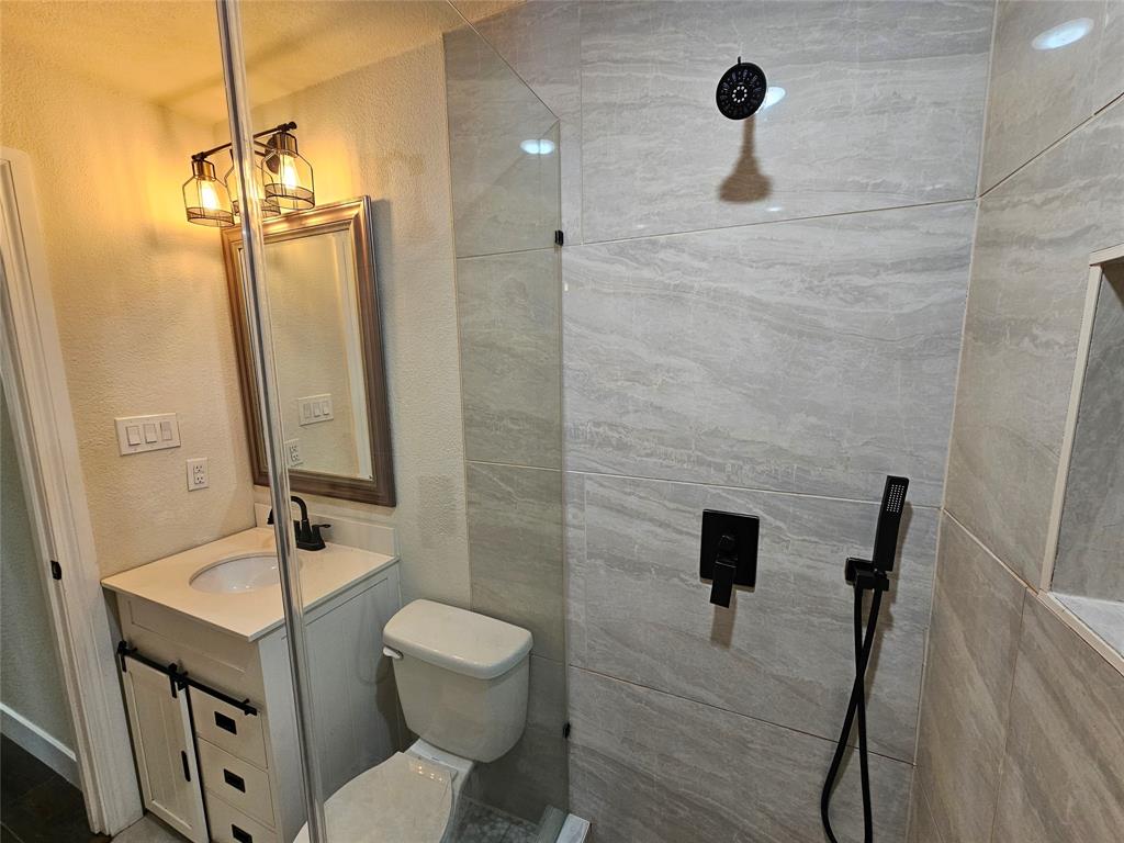 211 North Hampton Road Dallas, TX 75208 - Photo 19 of 22 Bathroom featuring a glass-enclosed shower with large format wall tiles