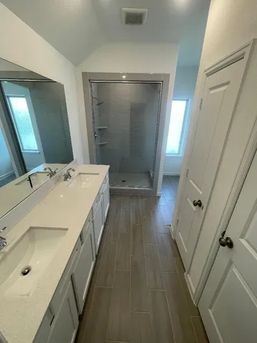 a bathroom with a double vanity sink and a mirror