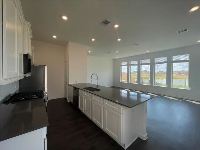 a kitchen with sink stove and refrigerator