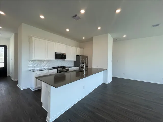 a kitchen with a sink stainless steel appliances and cabinets
