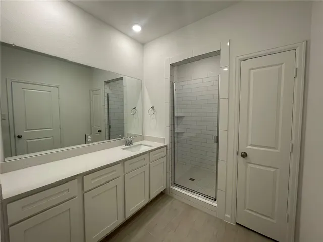 a spacious bathroom with a shower sink and mirror