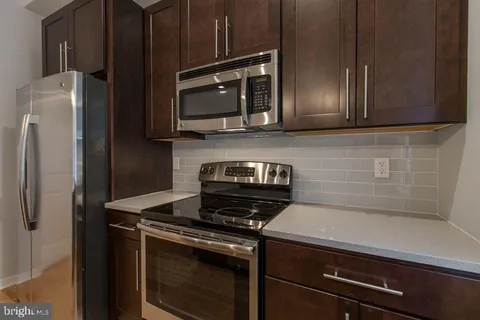 a kitchen with stainless steel appliances wooden cabinets and a stove top oven