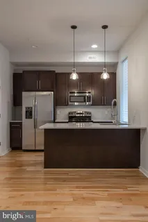 a kitchen with kitchen island a counter top a sink and stainless steel appliances