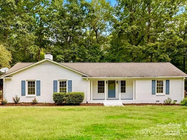 a front view of a house with a garden and yard