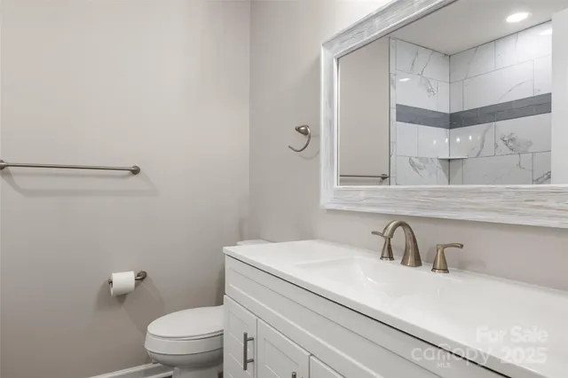 a bathroom with a sink a toilet and a mirror