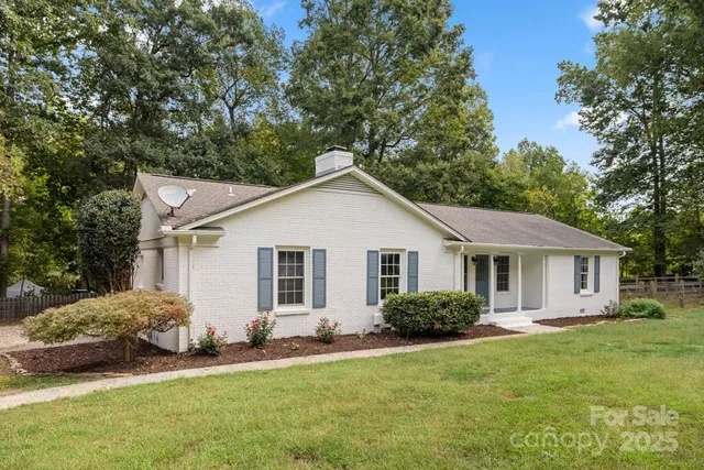 a view of a house with a yard and potted plants