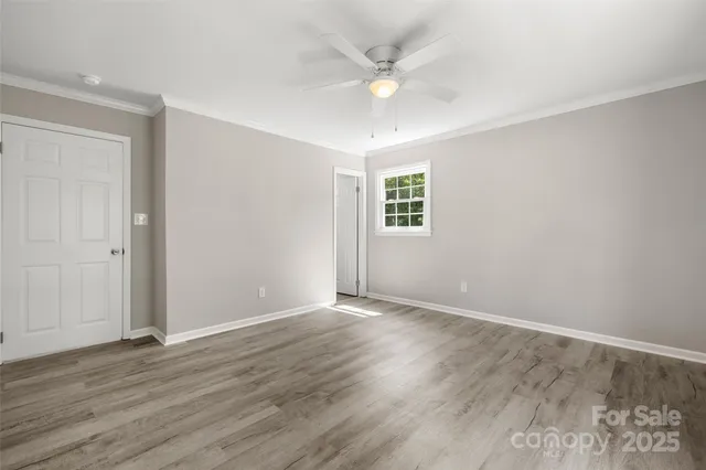 an empty room with wooden floor and window