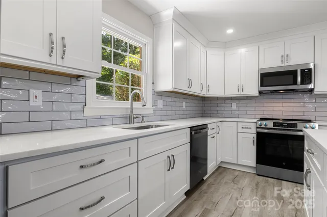 a kitchen with stainless steel appliances granite countertop a sink and a stove