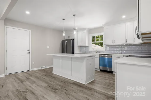 a kitchen with a sink cabinets and wooden floor