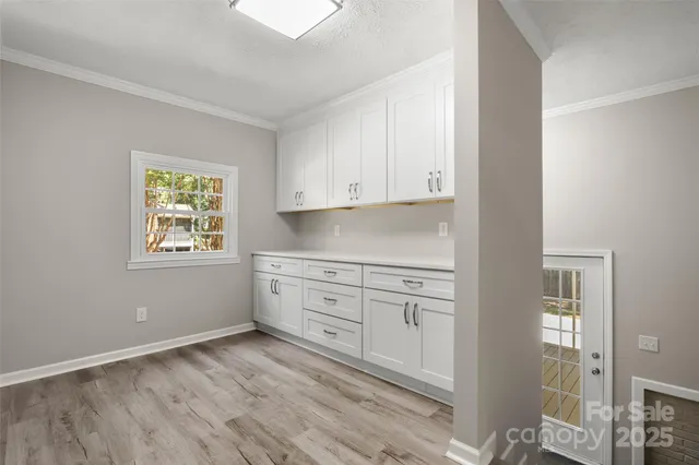 a kitchen with granite countertop white cabinets and window