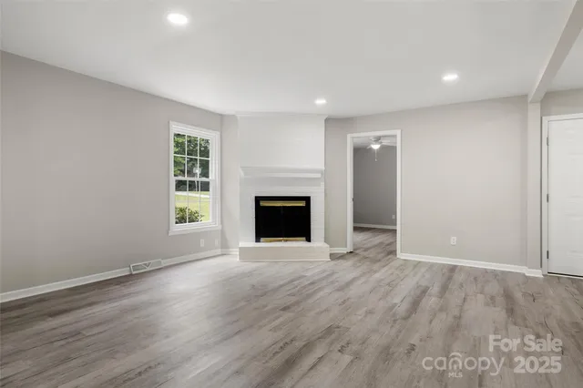 an empty room with wooden floor and a window