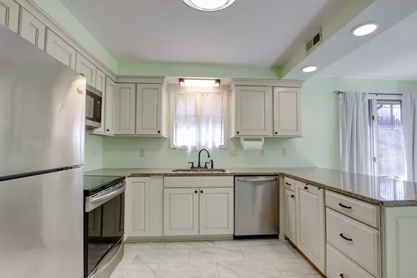 a kitchen with a refrigerator sink and cabinets
