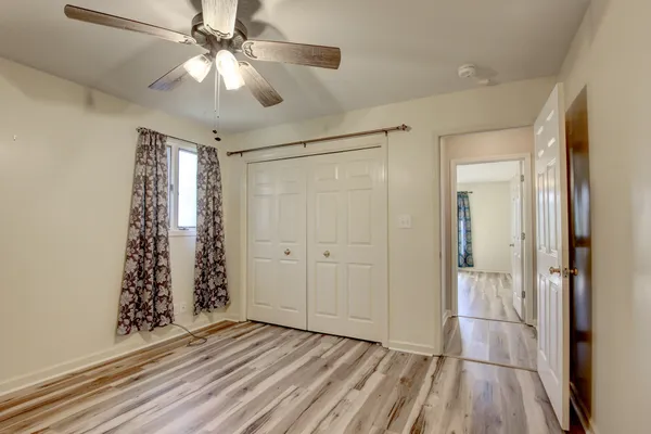 a spacious bedroom with a bed and a chandelier