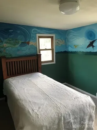 a bed sitting in a bedroom next to a window