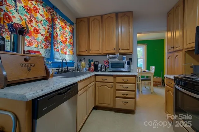 a kitchen with stainless steel appliances granite countertop a sink a stove and a microwave