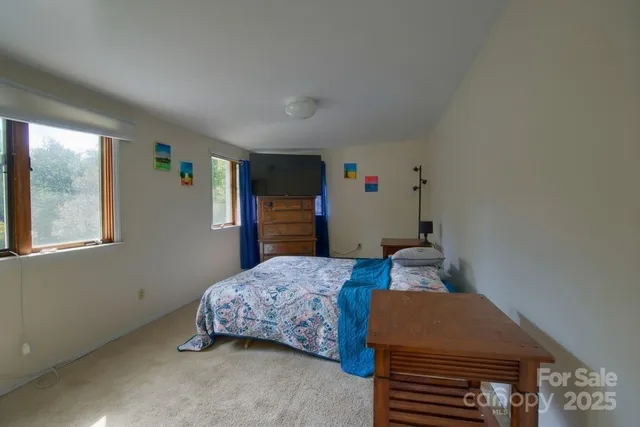 a bedroom with a bed and a dresser next to a window