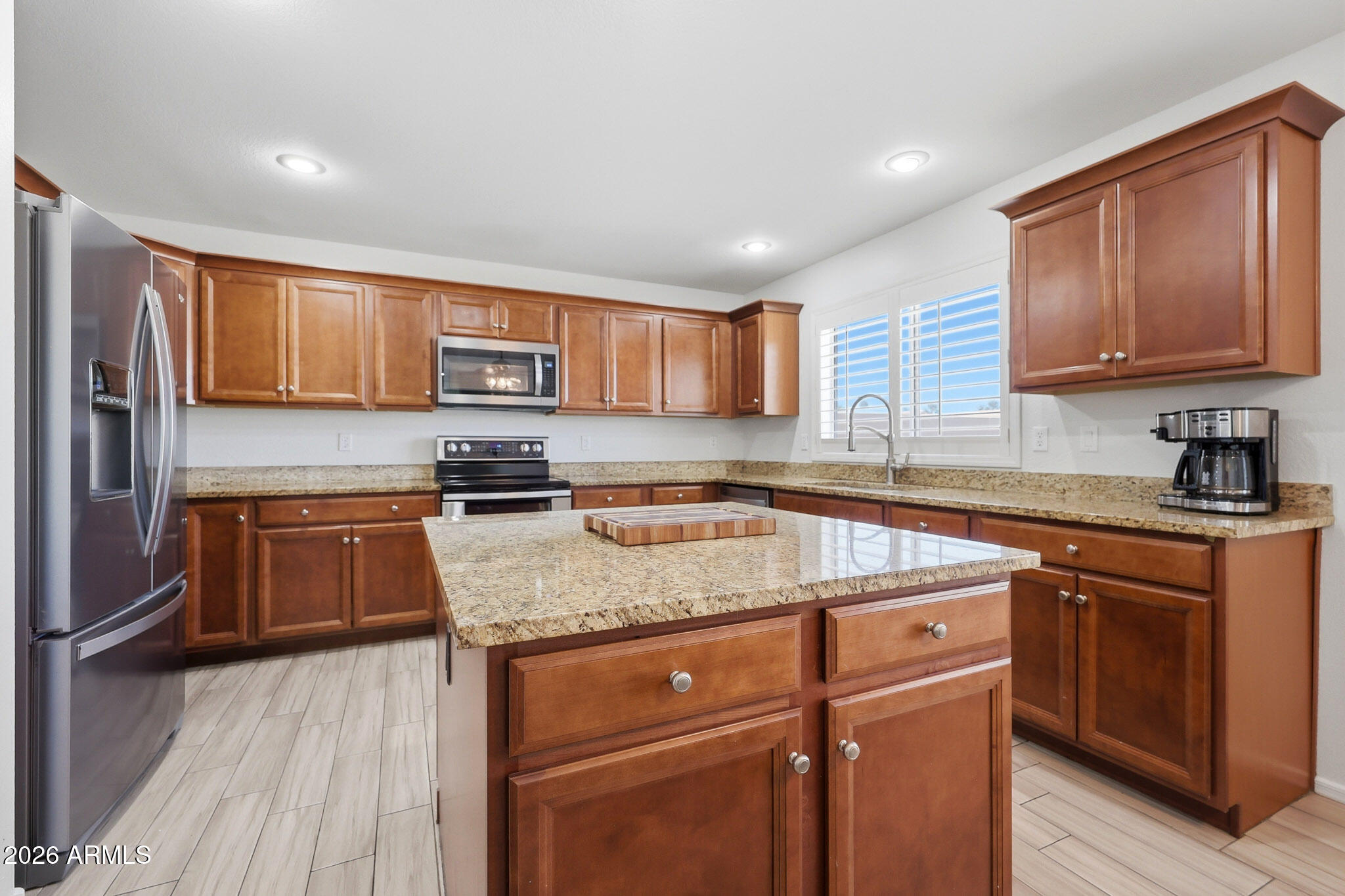 648 South Cholla Street Gilbert, AZ 85233 - Photo 8 of 46 a kitchen with granite countertop wooden cabinets and a stove top oven