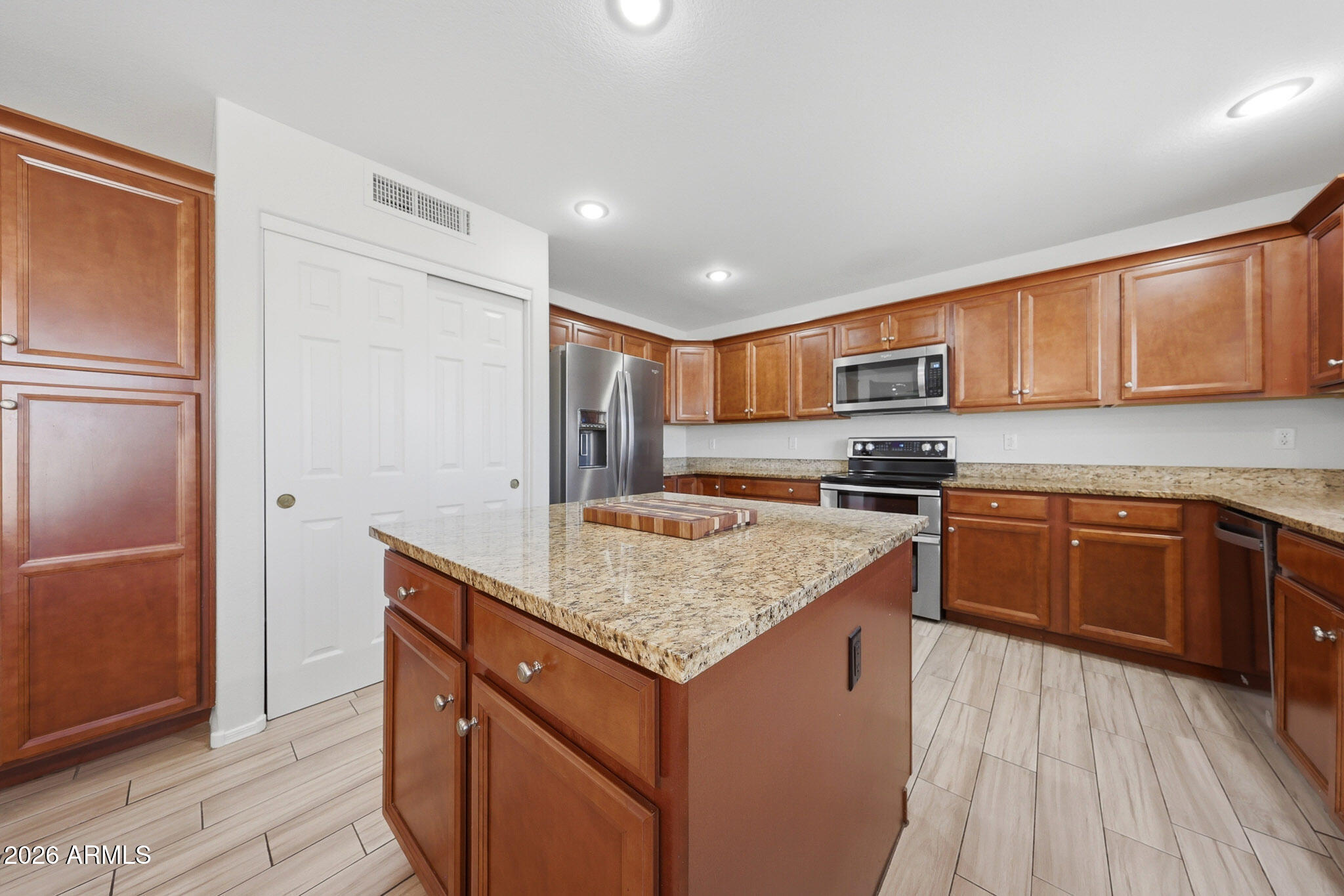 648 South Cholla Street Gilbert, AZ 85233 - Photo 9 of 46 a kitchen with stainless steel appliances granite countertop a stove a refrigerator and wooden cabinets
