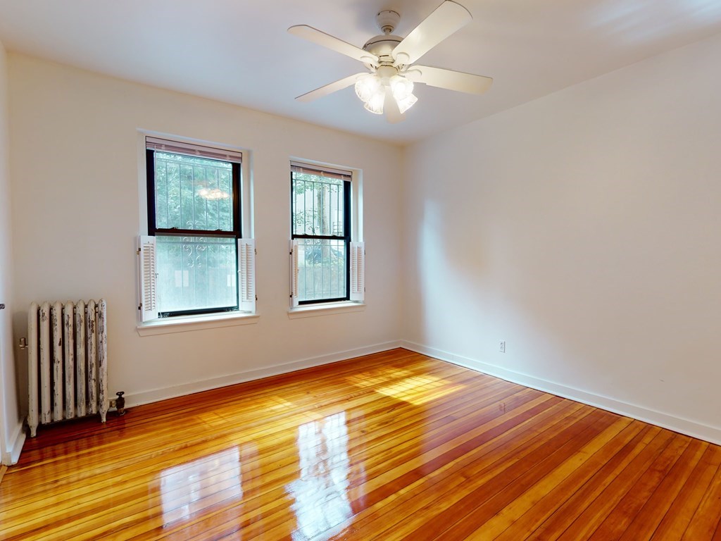 1404 Commonwealth Avenue, Unit 7 Boston, MA 02135 - Photo 11 of 19 a view of an empty room with wooden floor and a window