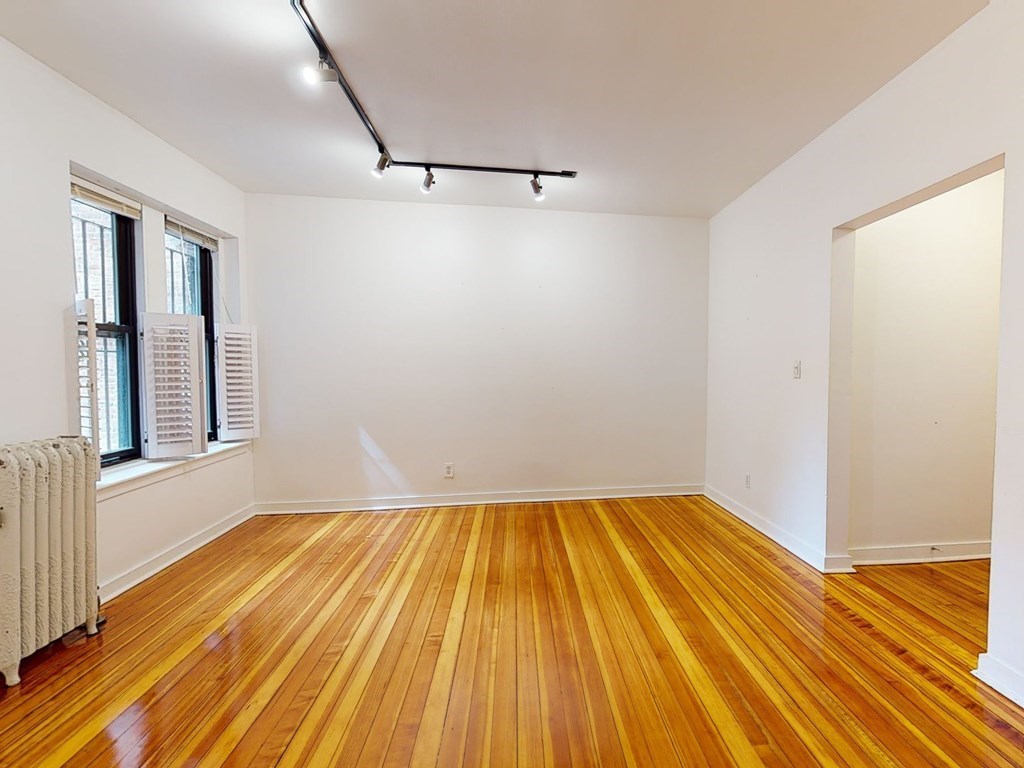 1404 Commonwealth Avenue, Unit 7 Boston, MA 02135 - Photo 15 of 19 a view of a room with wooden floor and brick walls