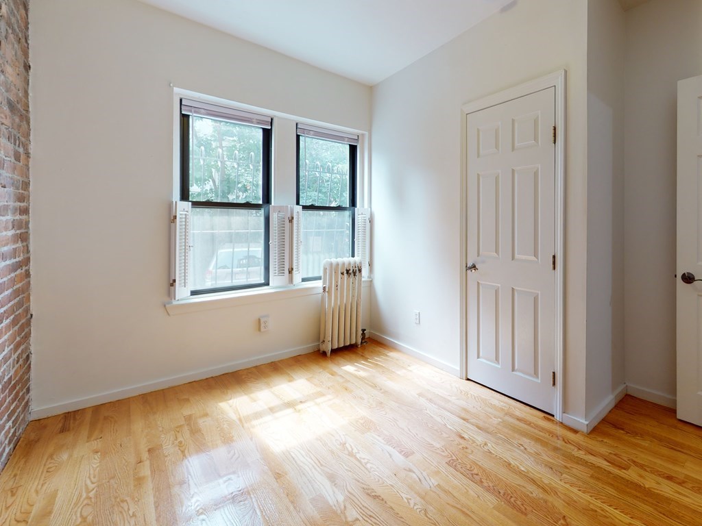 1404 Commonwealth Avenue, Unit 7 Boston, MA 02135 - Photo 3 of 19 an empty room with wooden floor and windows