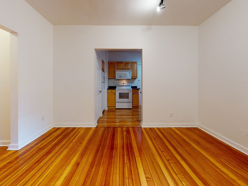 1404 Commonwealth Avenue, Unit 7 Boston, MA 02135 - Photo 4 of 19 a view of a room with wooden floor and staircase