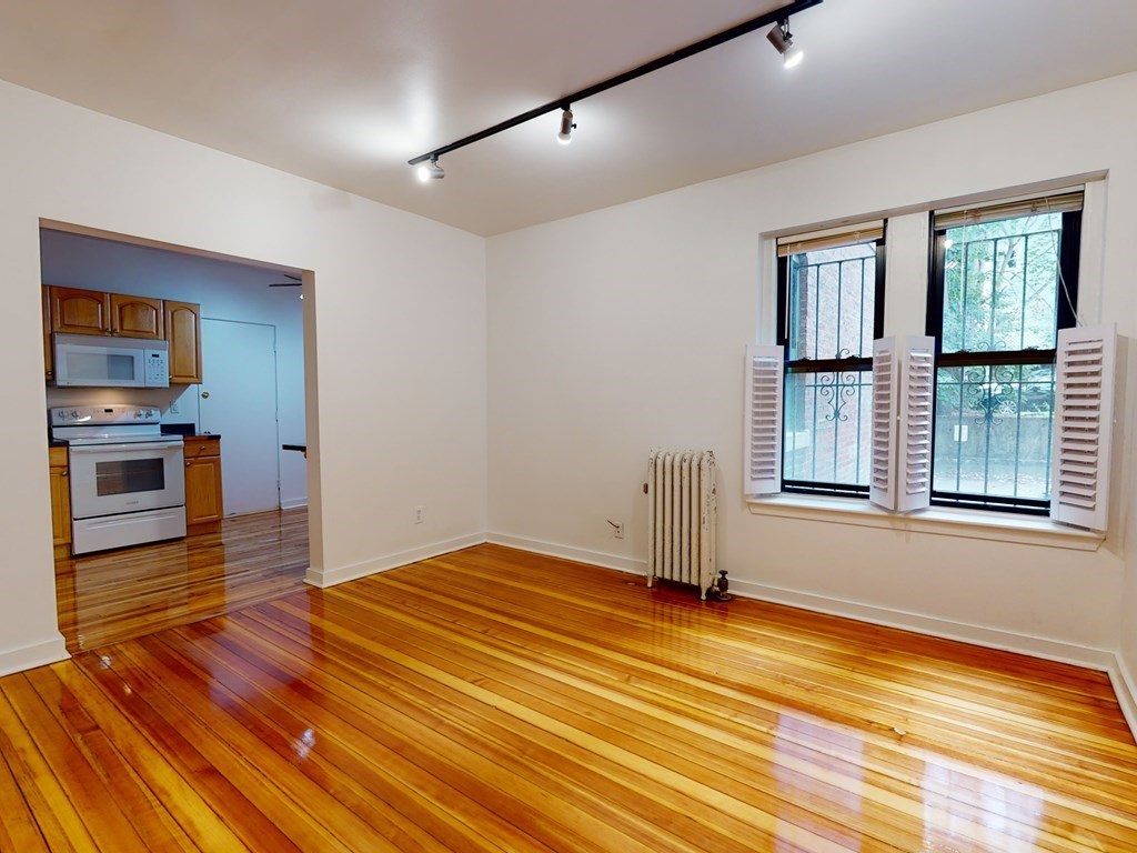 1404 Commonwealth Avenue, Unit 7 Boston, MA 02135 - Photo 5 of 19 a view of a livingroom with wooden floor and a ceiling fan