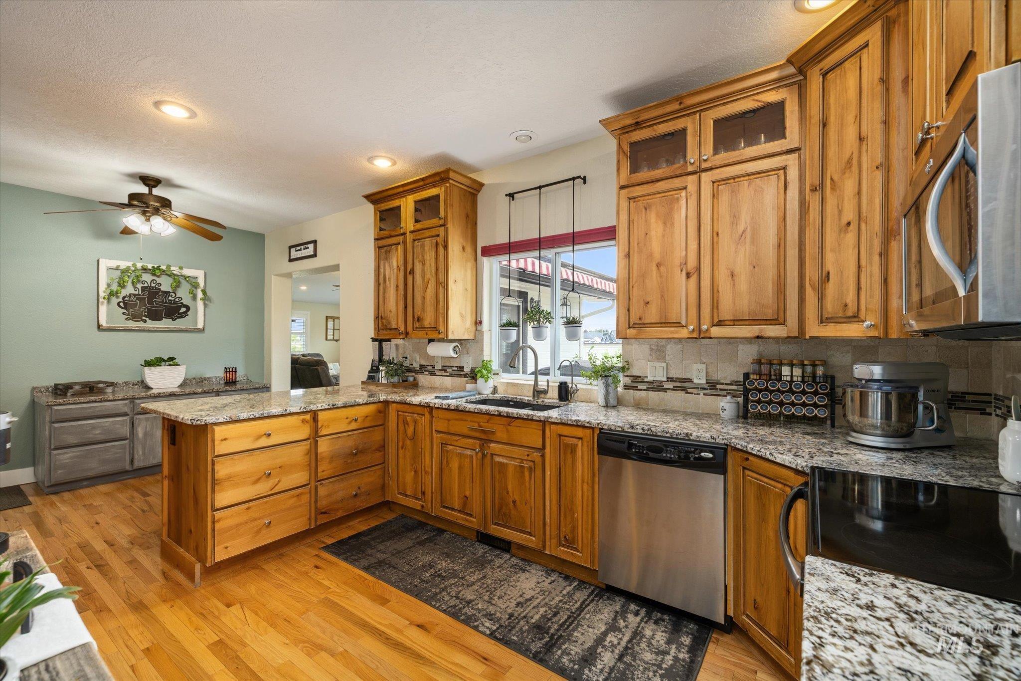 1140 Edgemont Road Emmett, ID 83617 - Photo 8 of 50 Kitchen featuring knotty alder cabinetry, granite countertops, stainless steel appliances, and wood-finish flooring