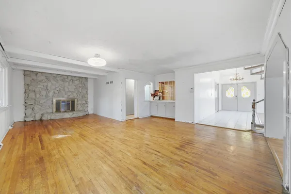 a view of empty room with wooden floor and fireplace